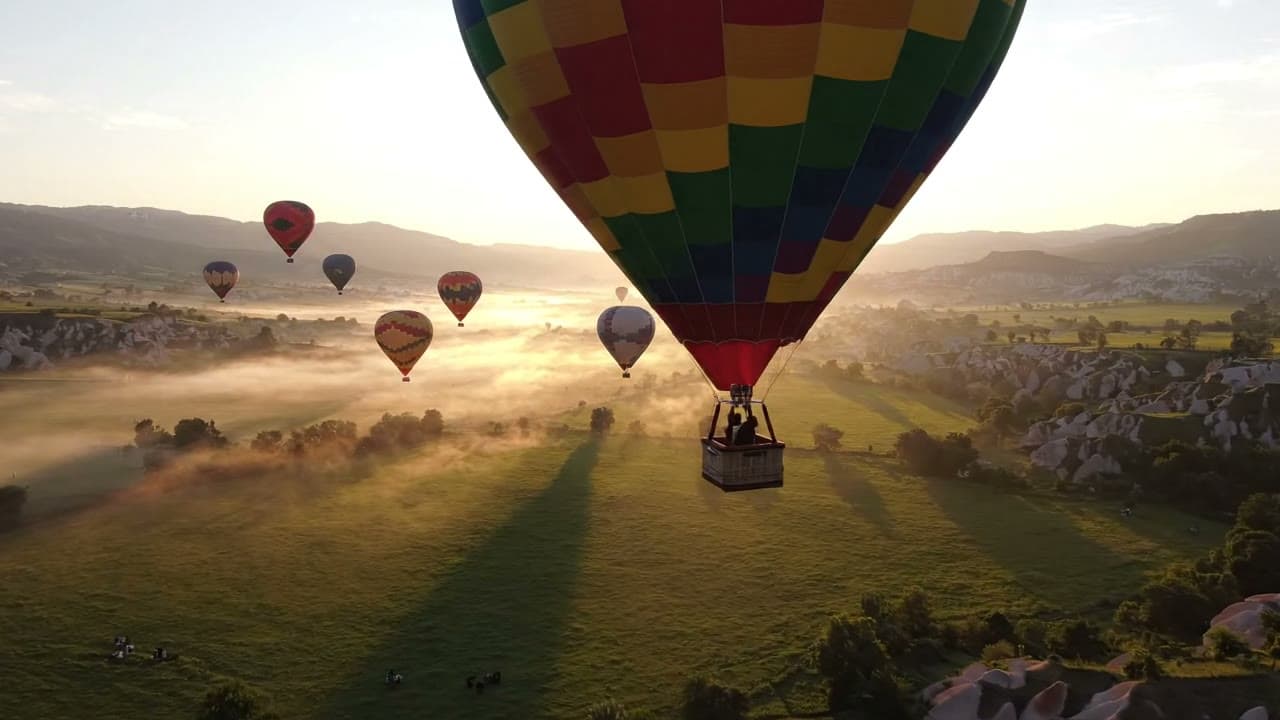 Hot Air Balloons Drifting Over a Misty Valley — Free AI Stock Video